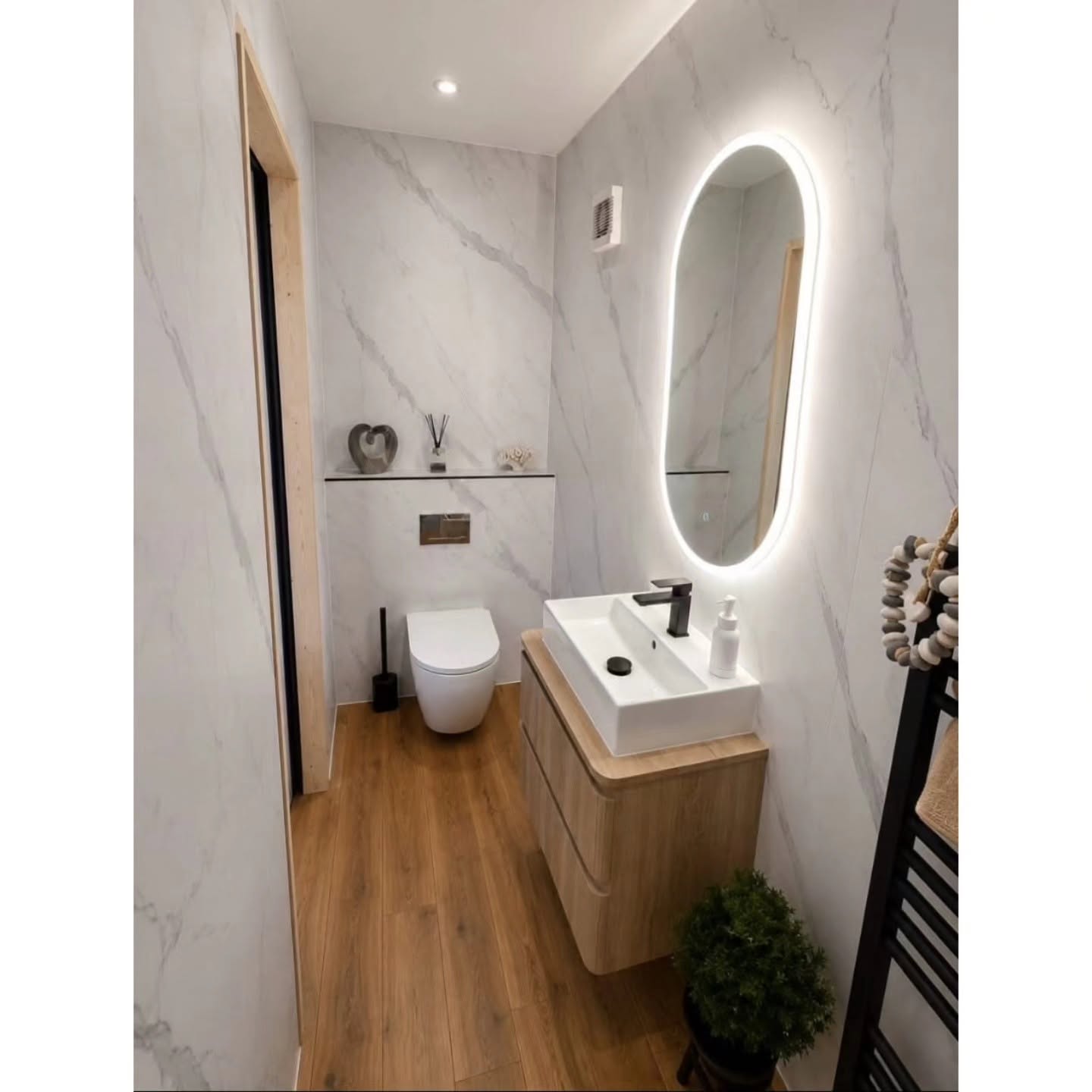 Finished en-suite with oak vanity, concealed toilet and illuminated mirror